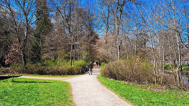 Einige Menschen sind am frühen Mittag bereits im Park unterwegs und genießen die Sonne.