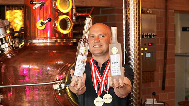 Kleinbrenner Ralf Löhle aus Meersburg mit seinen beiden Goldmedaillen um den Hals und seinen Gold-Kreationen: dem &bdquo;Brand von der ...