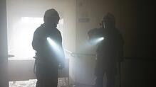 Schlechte Sicht: Im Rauch sind die Feuerwehrleute nur noch als Schemen zu erkennen.