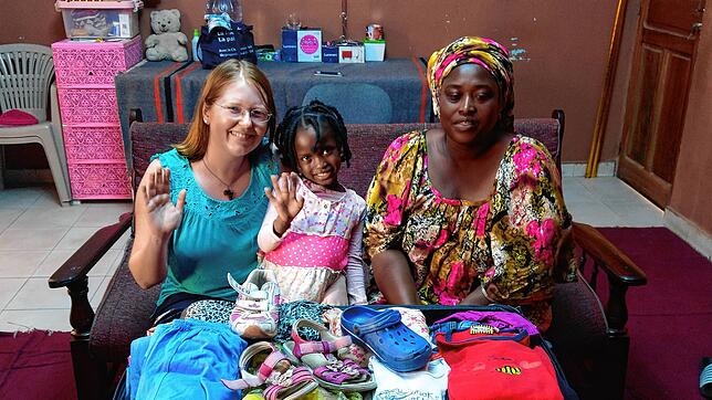 Lisa Meier bei der Übergabe von Kinderkleiderspenden an eine bedürftige Familie. Bei jedem Aufenthalt bringt sie einen großen Karton mit ...