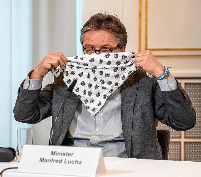 Manfred Lucha zeigt im März 2020 einen provisorischen Mundschutz.