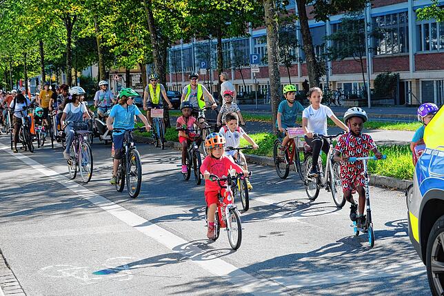 Gleich nach dem anführenden Polizeiwagen radelt – und rollert – eine Kindergruppe.