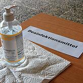 Vor dem Hauptportal des Gymnasiums steht eine Flasche mit Desinfektionsmittel für Schüler und Lehrer bereit.