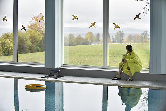 Im Schwimmbad gibt es Trompetenmusik, die scheinbar zufällig erklingt, aber einem strikten Zeitplan folgt, der auch gelegentlich einen ...