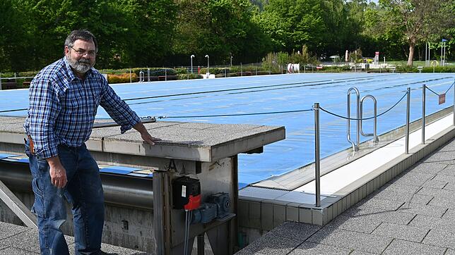 Gegen Wärmeverlust wird das Schwimmerbecken nachts mit einer schwimmfähigen Plane abgedeckt. Auf dem Bild Schwimmmeister Wolfgang Kromer ...