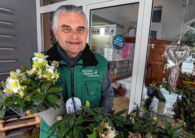 Thomas Trautwein bereitet bestellte Blumen im Außenbereich seines Ladengeschäftes zur Abholung durch einen Kunden auf.