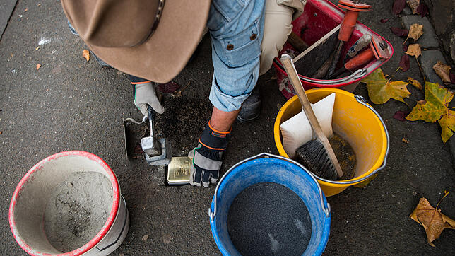 Gunter Demnig, Kölner Bildhauer und Ideengeber des Projektes Stolpersteine bei der Verlegung eines der Gedenksteine &ndash; hier der für ...