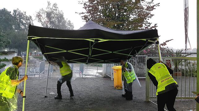 Mitarbeiter der Security-Firma packen im Sturm zusammen.