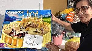 Die Leiterin des Ladens Renate Reinhart zeigt, dass man sogar Playmobilsets im Kleiderladen findet.