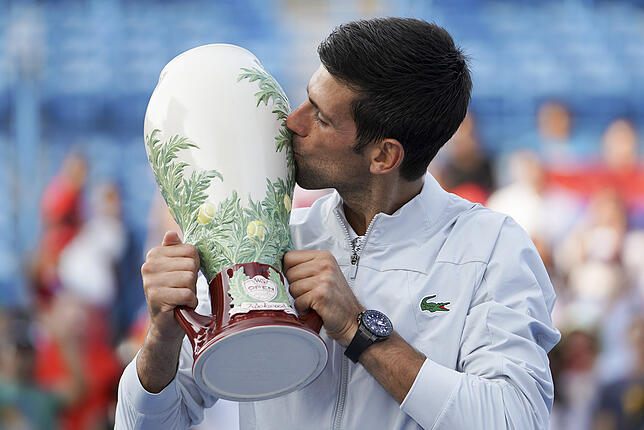 Ein Kuss für den begehrten Pokal: Novak Djokovic hat Geschichte geschrieben.