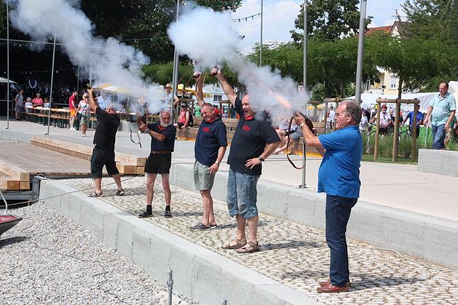 Fünf Mitglieder der Freiwilligen Feuerwehr beim Salutschießen zu Beginn des Festes.