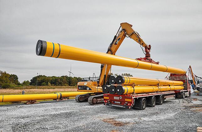 Ein Kran hebt ein Rohr von einem Transporter auf der Baustelle der Pipeline für das geplante schwimmende Flüssiggas-Terminal in ...