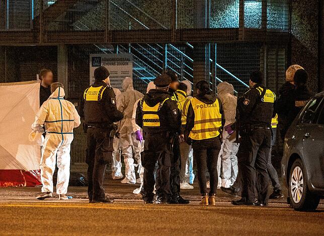Polizisten und Mitarbeiter der Spurensicherung stehen vor einem Gebäude der Zeugen Jehovas.