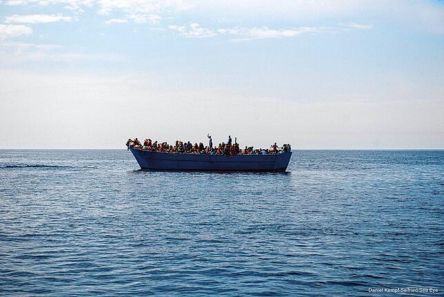 Ein völlig überladenes Schlepperboot mit Flüchtlingen unterwegs nach Europa. Die Insassen bezahlen viel Geld für die Überfahrt. Weil die ...