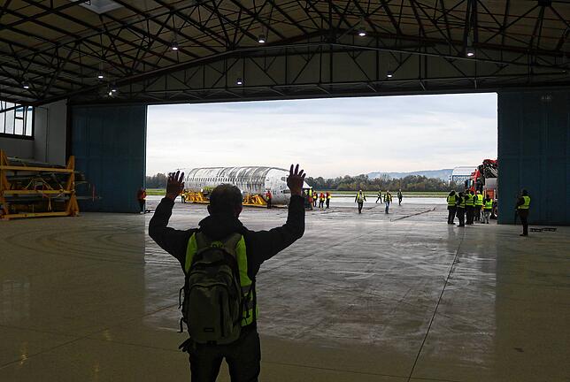 Der Rumpf der Landshut wird hier von einem Mitarbeiter in die neue Halle Q eingewiesen.