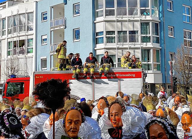 Feuerwehr genießt das Treiben auf ihrem Fahrzeug.
