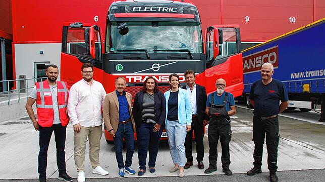 Abgeordnete schauen sich bei Transco einen E-Lkw an. Auf dem Bild (von links): Tim Buck (stellvertretender Niederlassungsleiter ...