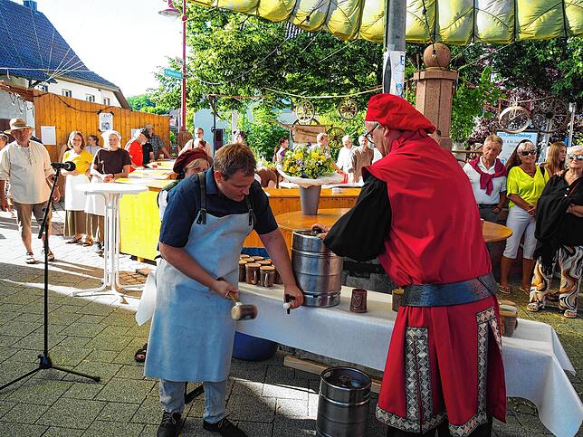 Bürgermeister Dominic Böhler (links) sticht das Fass an, Robert Binkert assistiert.