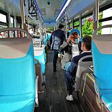 Im Innern des Busses: blaue Sitze und interessierte Fahrgäste.