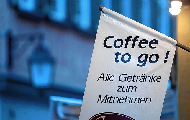 Alltag in deutschen Städten: Ein Ladengeschäft wirbt für Kaffee zum Mitnehmen. Geschieht das in Einwegbechern, landen diese im Müll. In ...