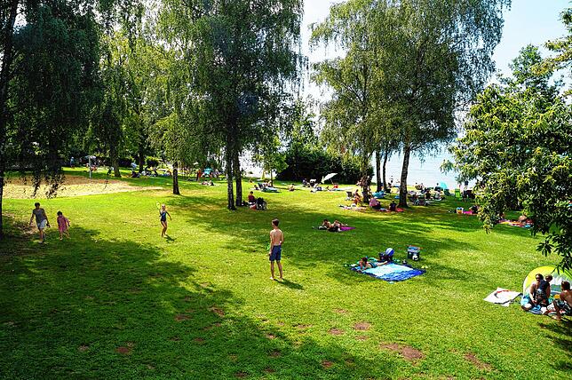 Ebenfalls frei zugänglich und weiterhin offen: Das Hagnauer Strandbad lockt mit großen Bäumen als Schattenspender und einem Sprungturm ...
