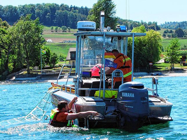 Rettungsschwimmer Simon Büche kehrt auf das DLRG-Rettungsboot zurück.