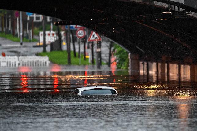 Nur das Dach eines Autos schaut in Köln noch aus dem Wasser, das eine Bahnunterführung geflutet hat.