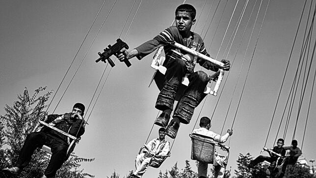 Kindheit in einer vom Krieg zerrütteten Gesellschaft, fotografiert von Anja Niedringhaus: In Kabul hält ein Junge eine Spielzeugwaffe, ...