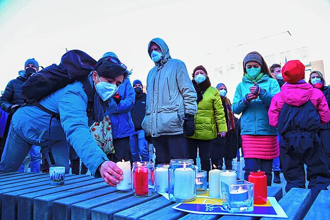 Als Zeichen des Gedenkens und der Solidarität zu den Menschen in der Ukraine zünden viele der Anwesenden eine Kerze an.