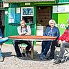 Mitarbeiter Sebastian Legde, Stefan, Christine und Roland Stärr sitzen vor dem Kiosk &bdquo;Zum Schorsch&ldquo; am Fischbacher Ufer. ...
