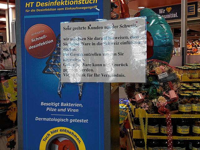 Desinfektion für den Wagen und freundlicher Hinweis für Schweizer Kunden: In einem Einkaufsmarkt werden Schweizer Kunden auf die ...