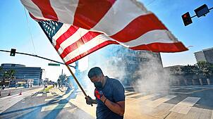Ein Demonstrant hält in Santa Ana die US-Flagge, nachdem die Polizei Tränengas und Blendgranaten vor dem Bundesgebäude eingesetzt hat.