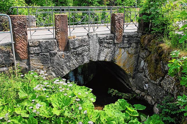 Wer von oben kommt, passiert zuerst die Brücke über den Leiterbach mit ihrem schmiedeeisernen Geländer.