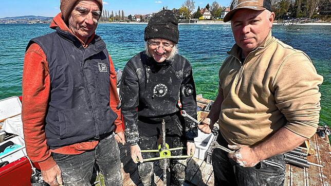 Jamie Macintosh, Joachim Köninger und Dominic Winstel (links) vom Pfahlbaumuseum auf einer Holzplattform, von der aus sie Sedimentproben ...