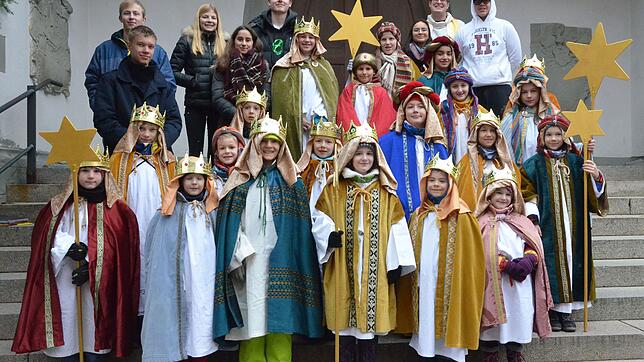 Sternsinger, der Vikar, Simon Dreher, und die jugendlichen Helfer von den Ministranten haben sich auf den Stufen der St.-Nikolaus-Kirche ...