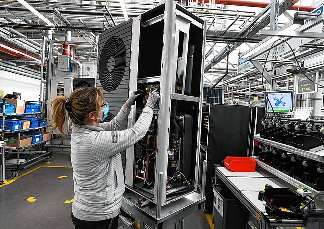 Steigende Nachfrage bei den Heizungsherstellern: Eine Mitarbeiterin der Firma Vaillant montiert eine Wärmepumpe im Werk in Remscheid.