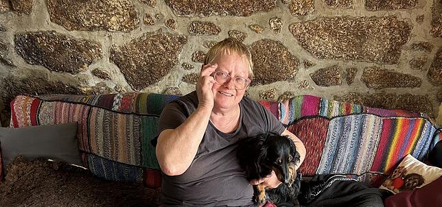 Endlich ein eigenes Zuhause: Renterin Birgit Reuner und ihr Dackel Max machen es sich auf ihrer Couch gemütlich.