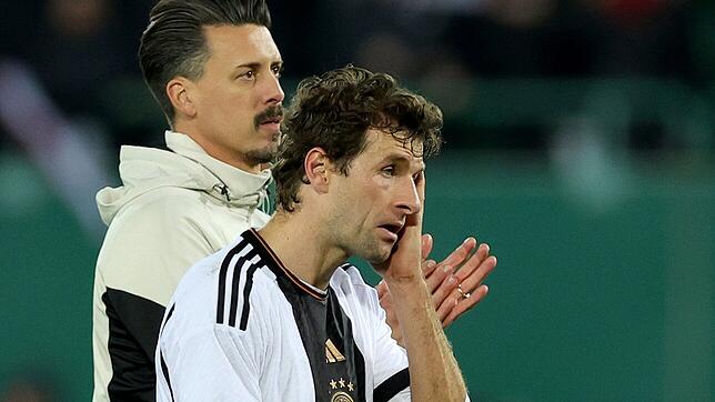 Deutschlands Assistenztrainer Sandro Wagner (l) und Thomas Müller gehen nach dem Spiel gegen Österreich enttäuscht über den Platz.