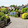 Eine typische Straße in der Waldsiedlung Reichenau: Einzelne Häuser mit viel Grün und Garten drumherum.