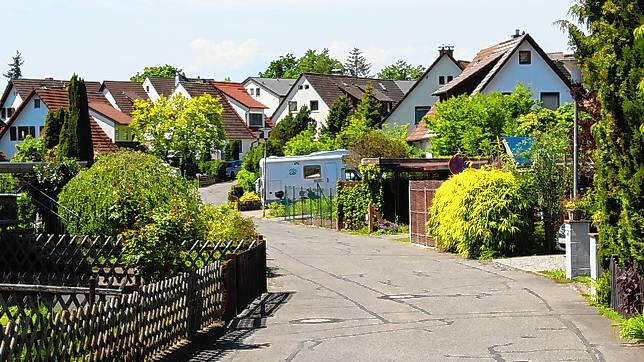 Eine typische Straße in der Waldsiedlung Reichenau: Einzelne Häuser mit viel Grün und Garten drumherum.
