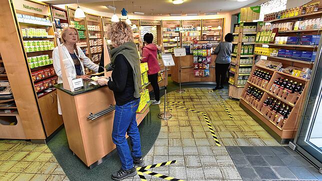 Birgit Kuttruff-Soffel bedient eine Kundin in der Schellenberg-Apotheke. Eine Glasscheibe gibt der Apothekerin einen Schutz vor einer ...