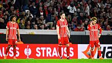 Freiburgs Kiliann Sildillia (l-r), Michael Gregoritsch und Ritsu Doan stehen nach dem Tor zum 0:1 auf dem Rasen.