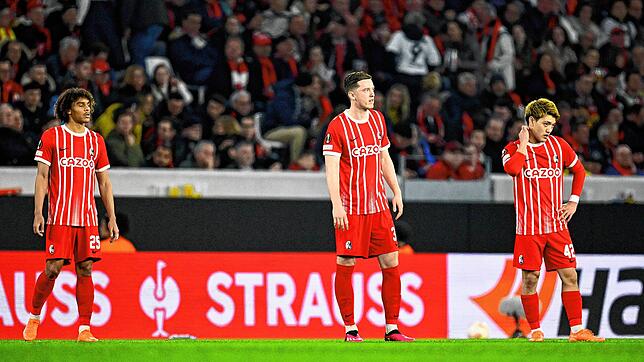 Freiburgs Kiliann Sildillia (l-r), Michael Gregoritsch und Ritsu Doan stehen nach dem Tor zum 0:1 auf dem Rasen.