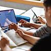 Schüler eines Gymnasiums in Karlsruhe sitzen vor einem Computer und benutzen ein KI-Tool.