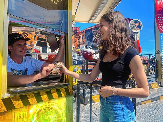 Leon Frey verkauft der Reporterin Vivienne Joos eine Eintrittskarte für das Fahrgeschäft „Steamer“ für 5 Euro.