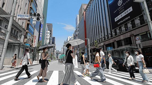 Viel ist auf Tokios Straßen in der Sommerhitze nicht los &ndash; wer sich nach draußen wagt, greift gern zum Schirm als Sonnenschutz.