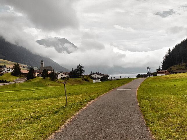 Oben angekommen – statt Belohnung, vorbei mit dem schönen Wetter! Wolken über dem Reschensee