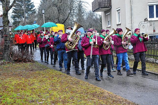 Bei strömenden Regen zogen die Osemalis mit der Musikkapelle Tannheim in Richtung Schule.