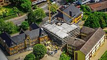 Inmitten der drei älteren Gebäude steht der Rohbau für den neuen Zwischenbau der Stockacher Grundschule.