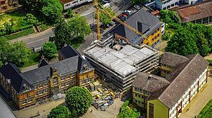 Inmitten der drei älteren Gebäude steht der Rohbau für den neuen Zwischenbau der Stockacher Grundschule.